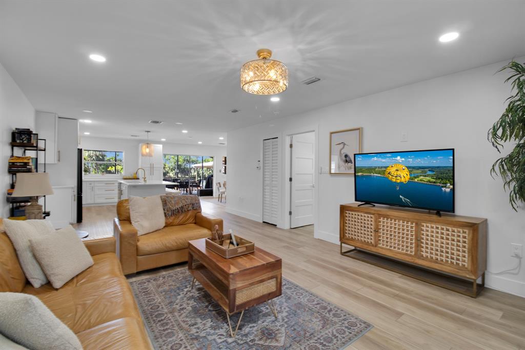 A living room with tan leather sofas, a wooden coffee table, and a television console — 1155 LEMON BLUFF ROAD, OSTEEN, FL