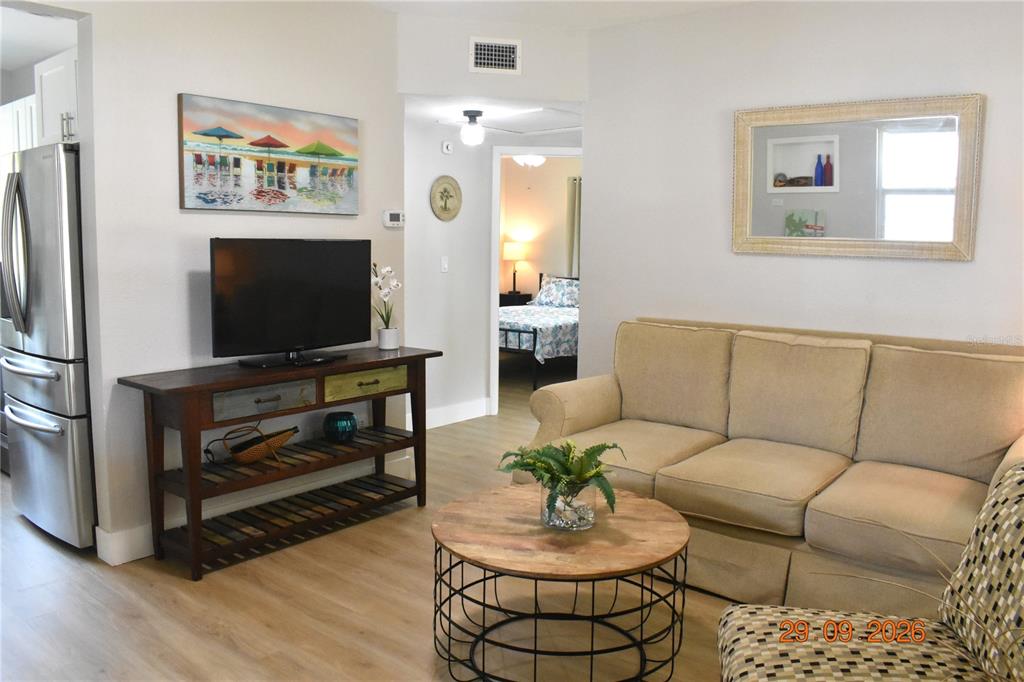A screened-in porch with a white brick base and a metal awning sits outdoors — 5165 104TH WAY N, ST PETERSBURG, FL
