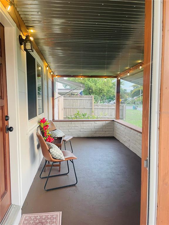 A covered patio features light gray horizontal siding, a concrete floor, and two white doors — 5165 104TH WAY N, ST PETERSBURG, FL