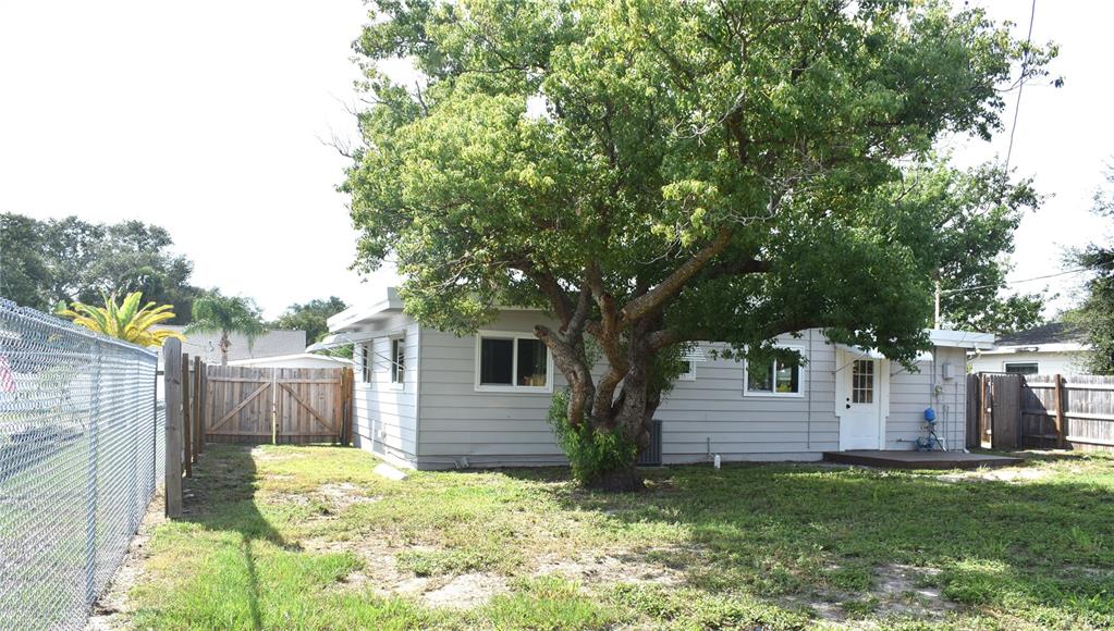 A white door sits next to a screened-in porch with a white brick base — 5165 104TH WAY N, ST PETERSBURG, FL