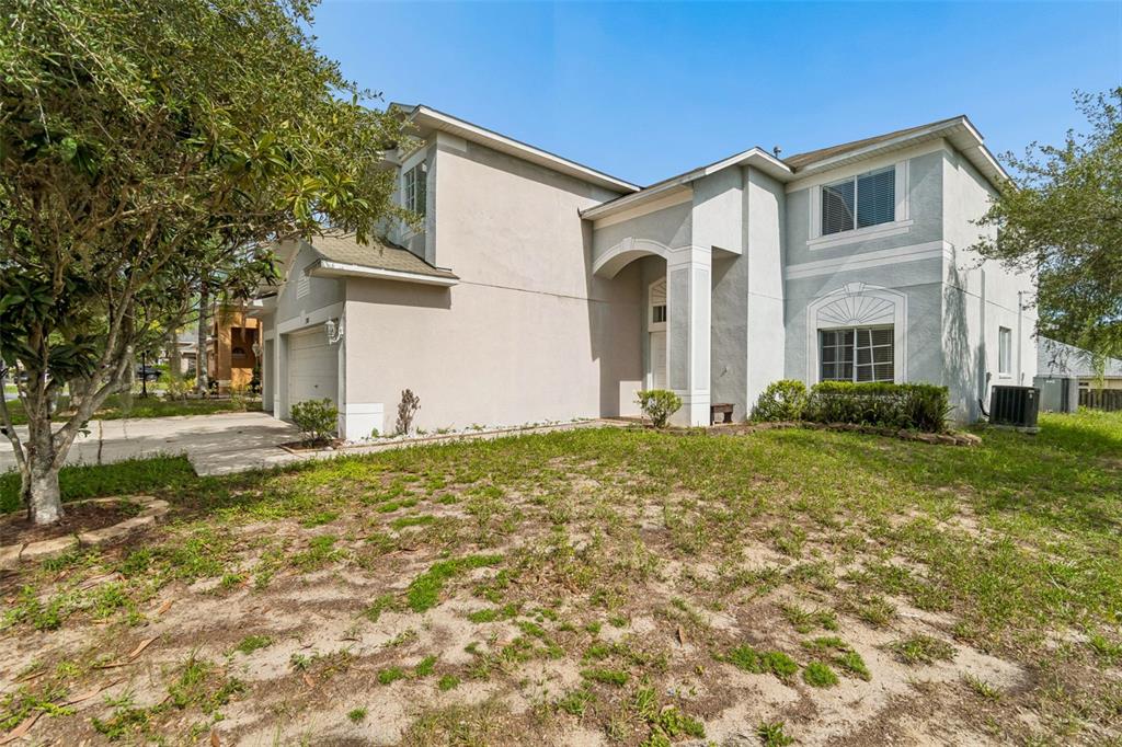A two-story house with a light-colored stucco exterior, a two-car garage, and a front lawn — 3307 PINE TOP DRIVE, VALRICO, FL