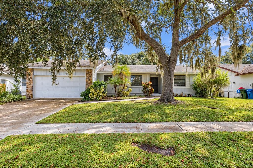A living room with tile flooring, a ceiling fan, and sliding glass doors to a patio — 2475 WOOD OAK DRIVE, SARASOTA, FL