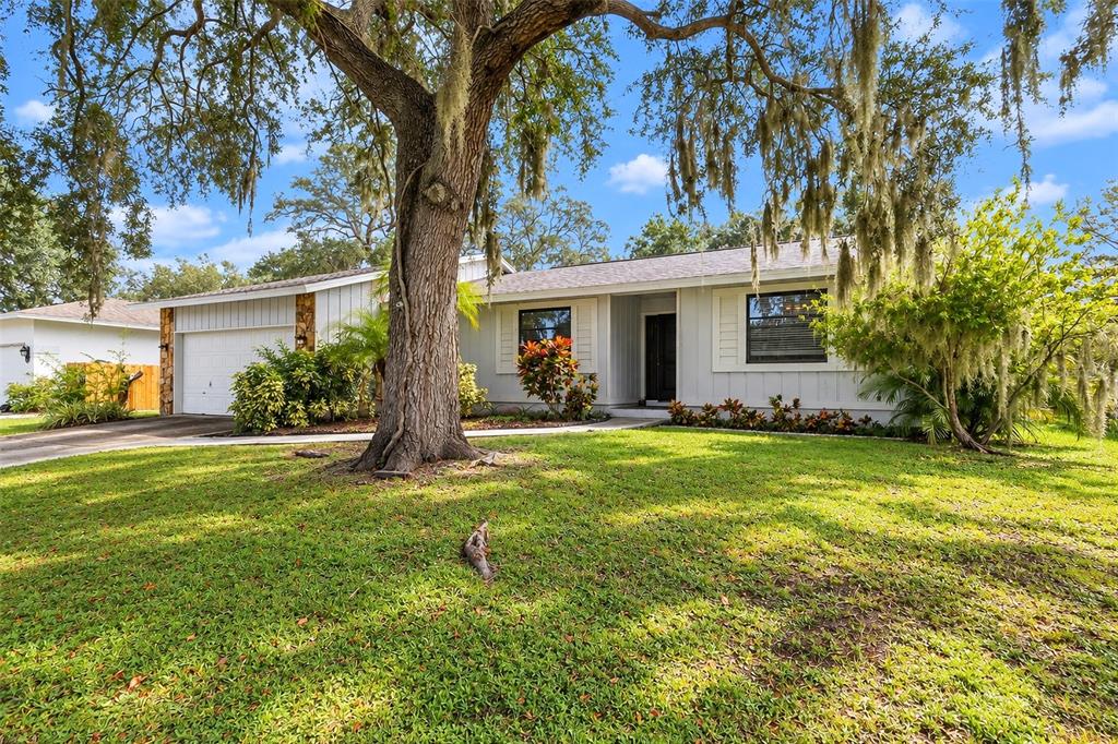 A kitchen with white cabinets, stainless steel appliances, granite countertops, and light-colored tile flooring — 2475 WOOD OAK DRIVE, SARASOTA, FL