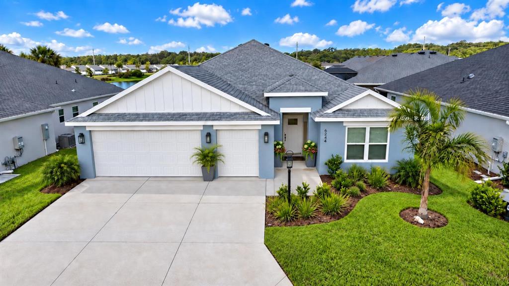 A bright entryway features a white front door, a glass pendant light, and light flooring — 6244 HANNAN LOOP, THE VILLAGES, FL