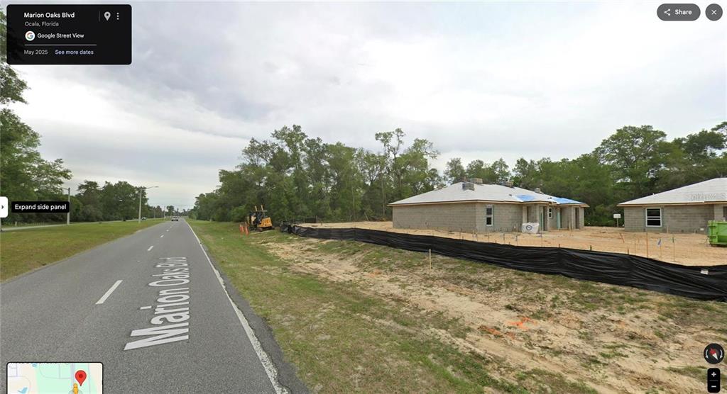 Two new houses under construction are visible along a paved road in a wooded area — MARION OAKS BLVD, OCALA, FL