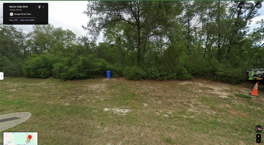A vacant, grassy lot with trees and a small blue utility box in the background — MARION OAKS BLVD, OCALA, FL