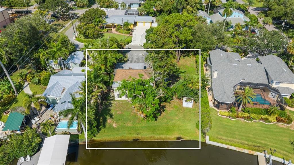 An aerial view of a waterfront house with a large tree in the backyard — 103 40TH STREET COURT NW, BRADENTON, FL
