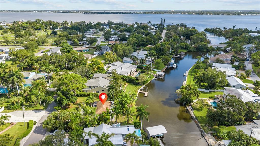 An aerial view shows a house with a red location pin near a canal — 103 40TH STREET COURT NW, BRADENTON, FL