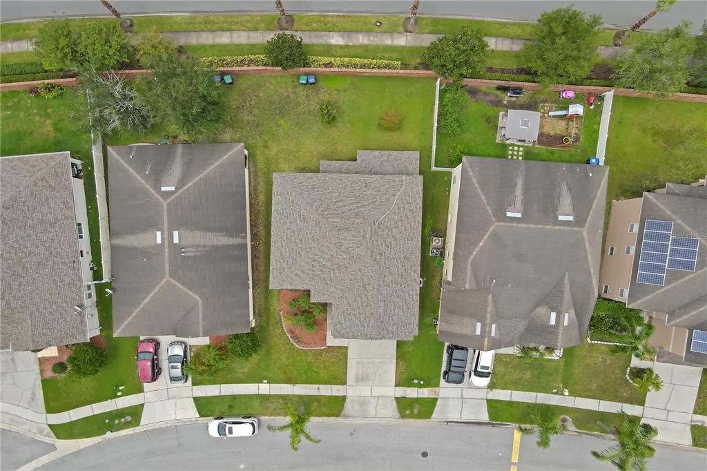 An aerial view shows three suburban houses with driveways, lawns, and roofs in a neighborhood — 2827 SAND ARBOR CIRCLE, ORLANDO, FL