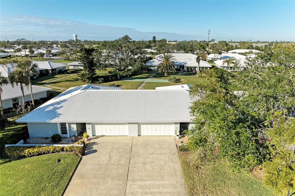 An aerial view of a single-story duplex with a white tile roof and concrete driveway — 6704 11TH AVENUE W, BRADENTON, FL