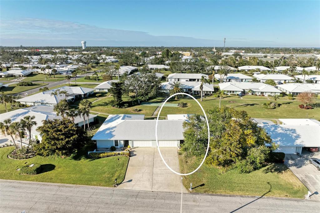 An aerial view shows a residential duplex with a white roof and concrete driveway — 6704 11TH AVENUE W, BRADENTON, FL