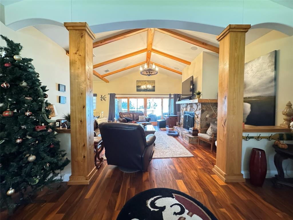 A living room features a stone fireplace, vaulted wood-beamed ceilings, and hardwood floors — 3108 N WHEATON POINT, HERNANDO, FL