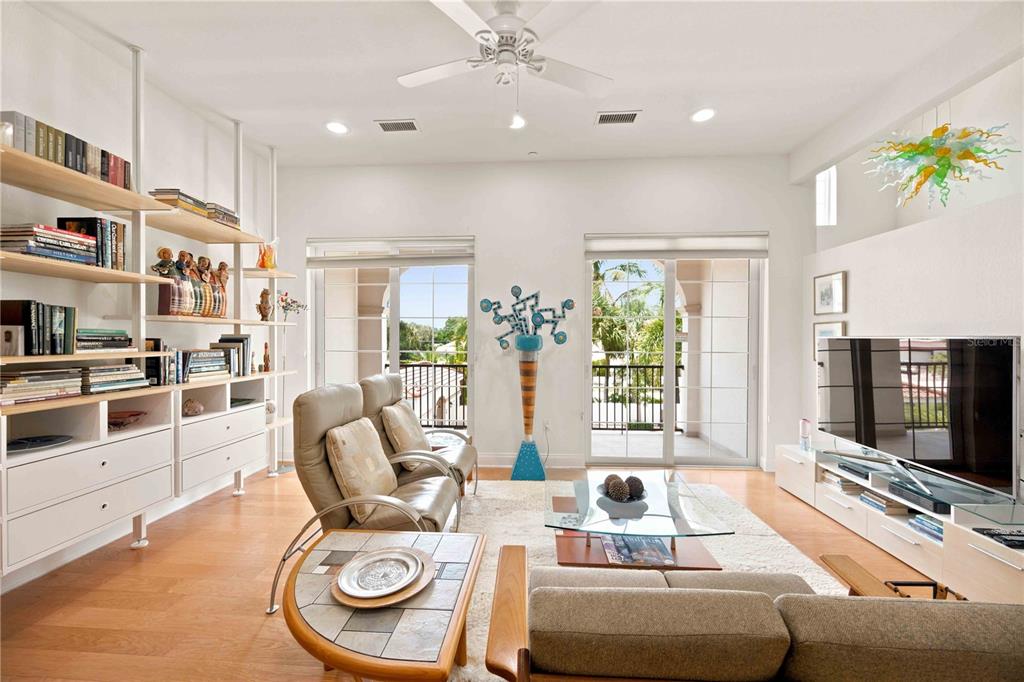 A kitchen island with a granite countertop and stainless steel sink overlooks an open living area — 435 NOKOMIS AVENUE S UNIT 312, VENICE, FL