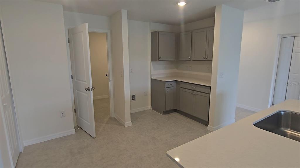 A kitchen area features gray cabinets, white countertops, and a sink on the foreground island — 541 LAKEVIEW COURT, POINCIANA, FL