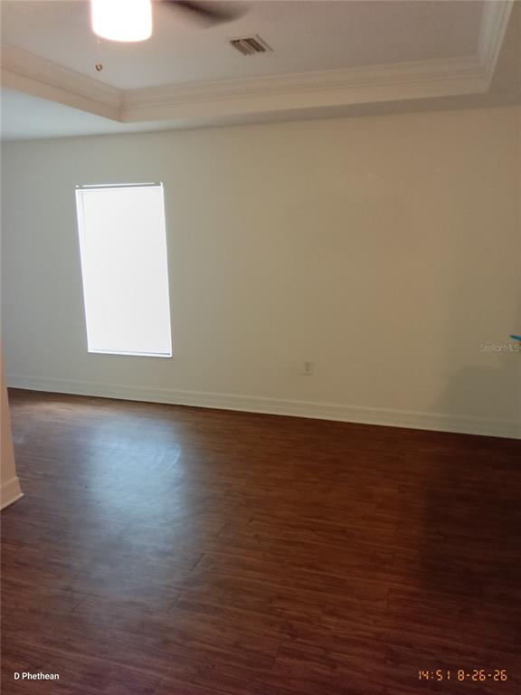 An empty room features wood-look flooring, white walls, a tray ceiling, and a single window — 3814 N GARRISON STREET UNIT B, TAMPA, FL