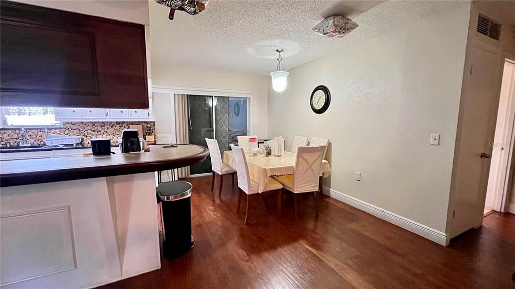 A dining area with a table, chairs, and a breakfast bar in a kitchen — 2615 CECILE STREET, KISSIMMEE, FL