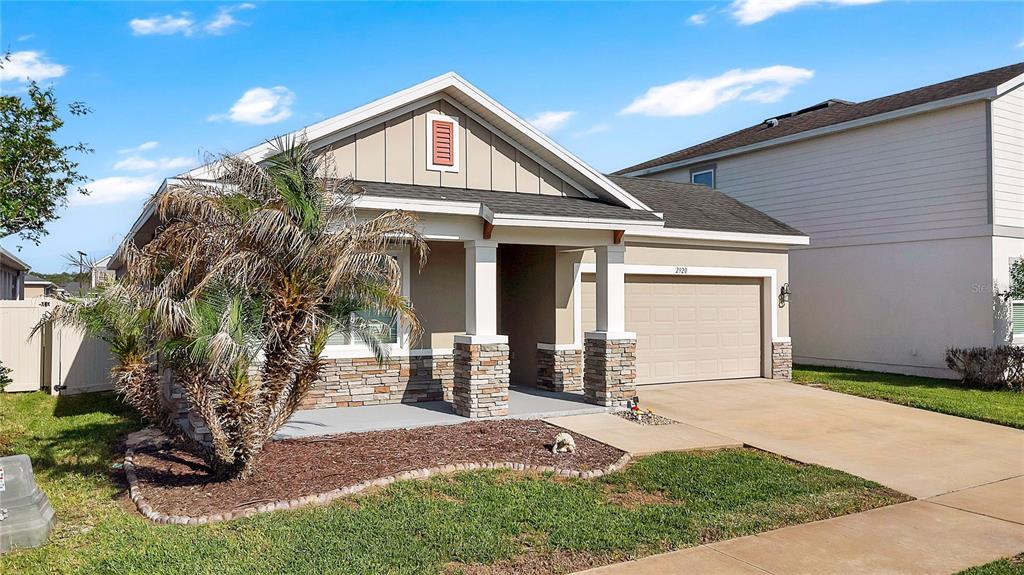 A single-story house with a stone-accented facade, a front porch, and an attached garage — 2920 MARLBERRY LANE, CLERMONT, FL