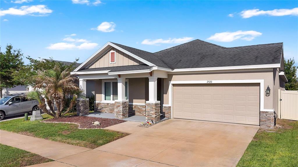 A single-story house with a stone-accented porch, a two-car garage, and a concrete driveway — 2920 MARLBERRY LANE, CLERMONT, FL