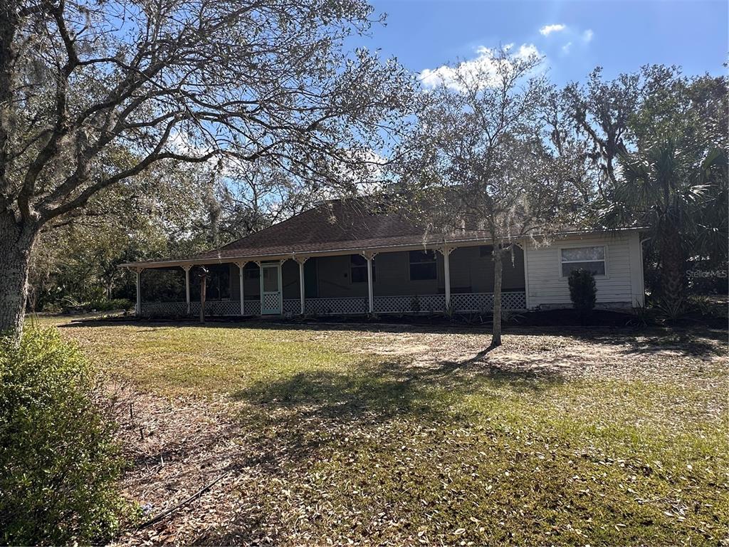 A single-story house with a wide, covered front porch and lattice skirting — 3900 CHALET SUZANNE DRIVE, LAKE WALES, FL