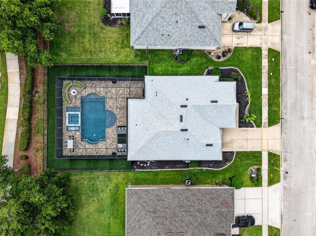 An aerial view shows a house with a screened-in pool, patio, and surrounding lawn — 5006 RISHLEY RUN WAY, MOUNT DORA, FL