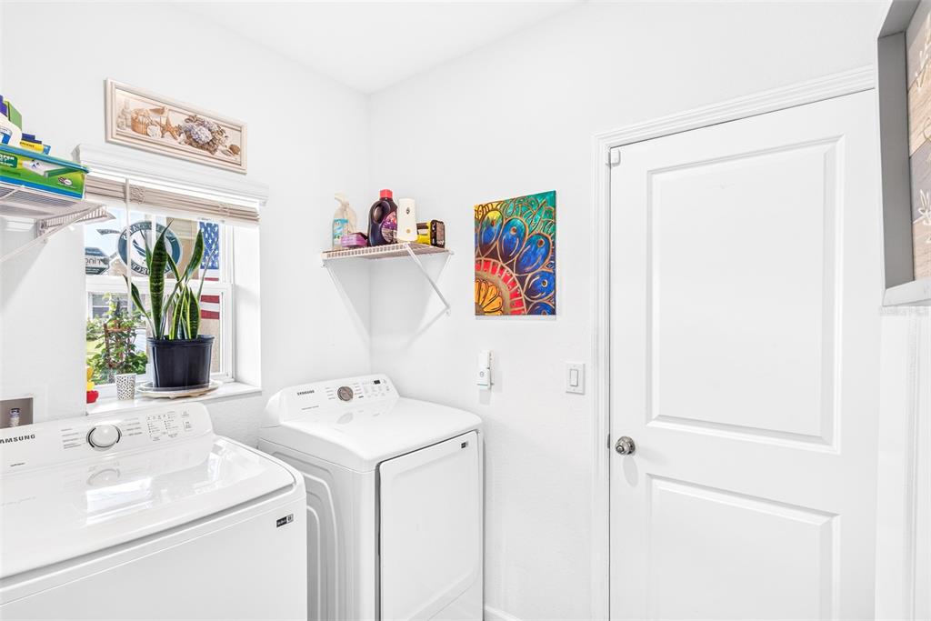 A laundry room features a white washer and dryer, a window, and a wall-mounted shelf — 617 TROTTERS DRIVE, EAGLE LAKE, FL