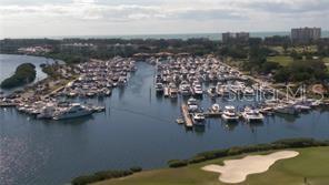 An aerial view shows a large marina filled with boats next to a golf course — 2800 HARBOURSIDE DRIVE UNIT E-07, LONGBOAT KEY, FL