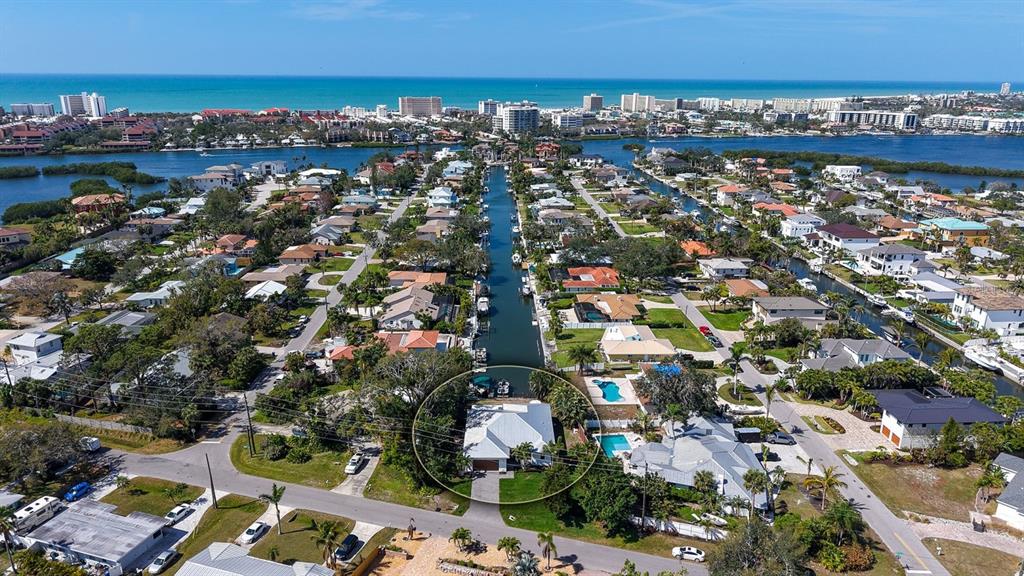 An aerial view shows a residential neighborhood with a canal and a circled house — 6136 HOLLYWOOD BOULEVARD, SARASOTA, FL