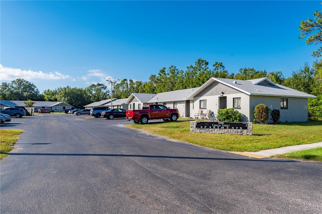 A single-story apartment complex with a parking lot and a red pickup truck parked outside — 1450 E GIBSON STREET, ARCADIA, FL
