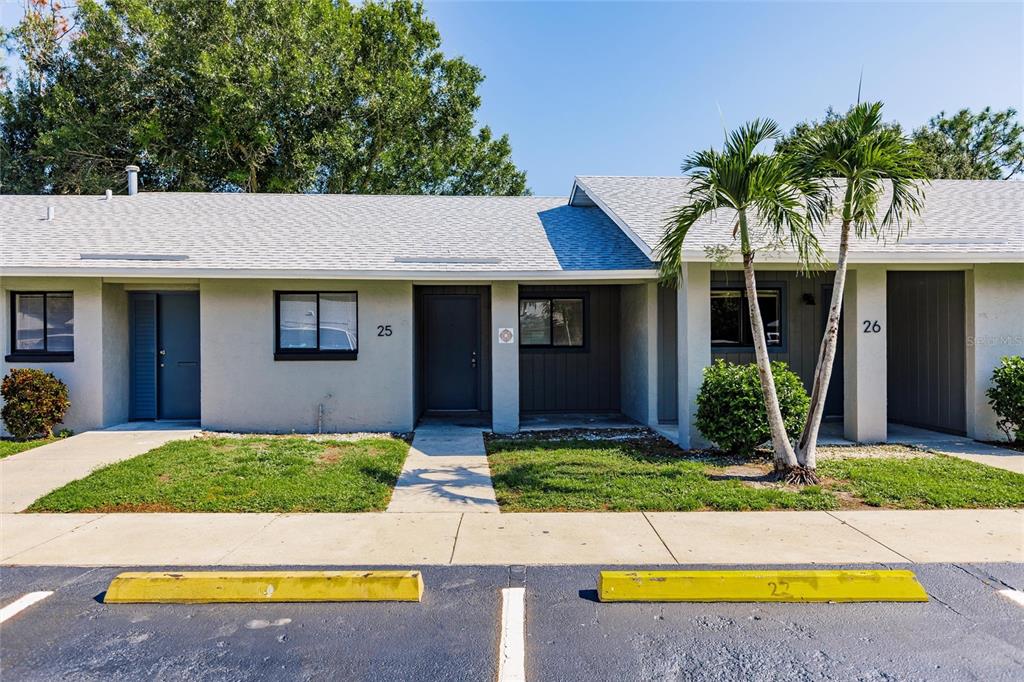 The exterior of a single-story residential building features two numbered units and palm trees — 1450 E GIBSON STREET, ARCADIA, FL