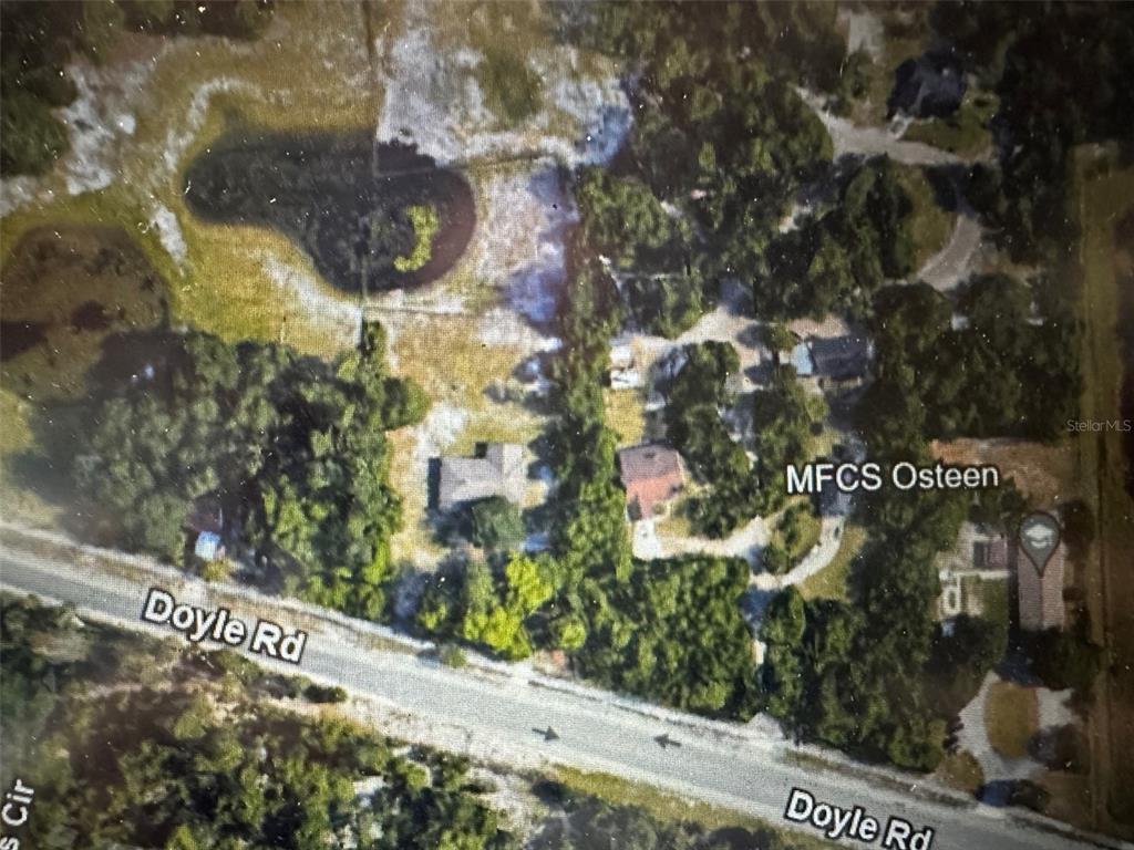This is an aerial map view showing houses, trees, a pond, and a road — DOYLE ROAD, OSTEEN, FL