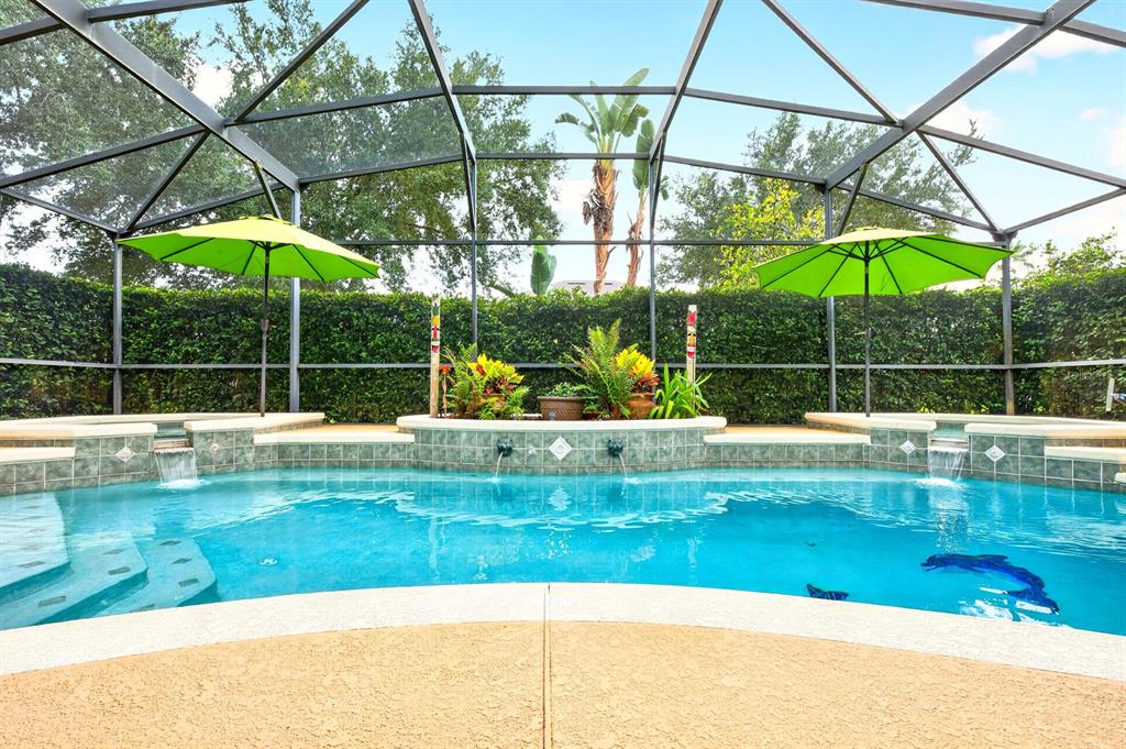 A covered patio with lounge chairs overlooks a swimming pool inside a screened-in enclosure — 10020 RUSTIC RIDGE COURT, ORLANDO, FL