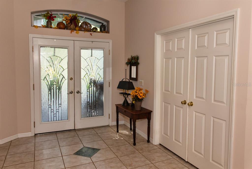 An entryway features a tiled floor, double front doors with glass inserts, and a closet — 5260 HAMMOCK CIRCLE, ST CLOUD, FL