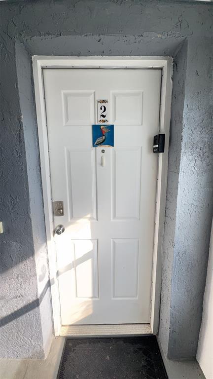 A white front door marked with the number two and a pelican decorative tile — 108 5TH ST SO UNIT 2B, FLAGLER BEACH, FL