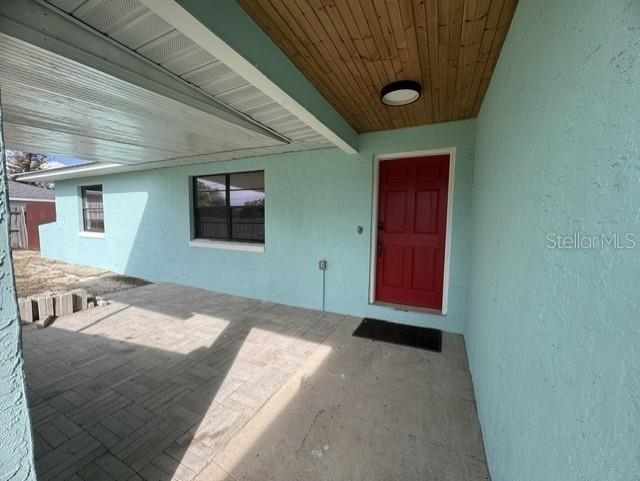 A light blue house exterior features a red front door and a paved patio area — 508 PARK DRIVE, BABSON PARK, FL