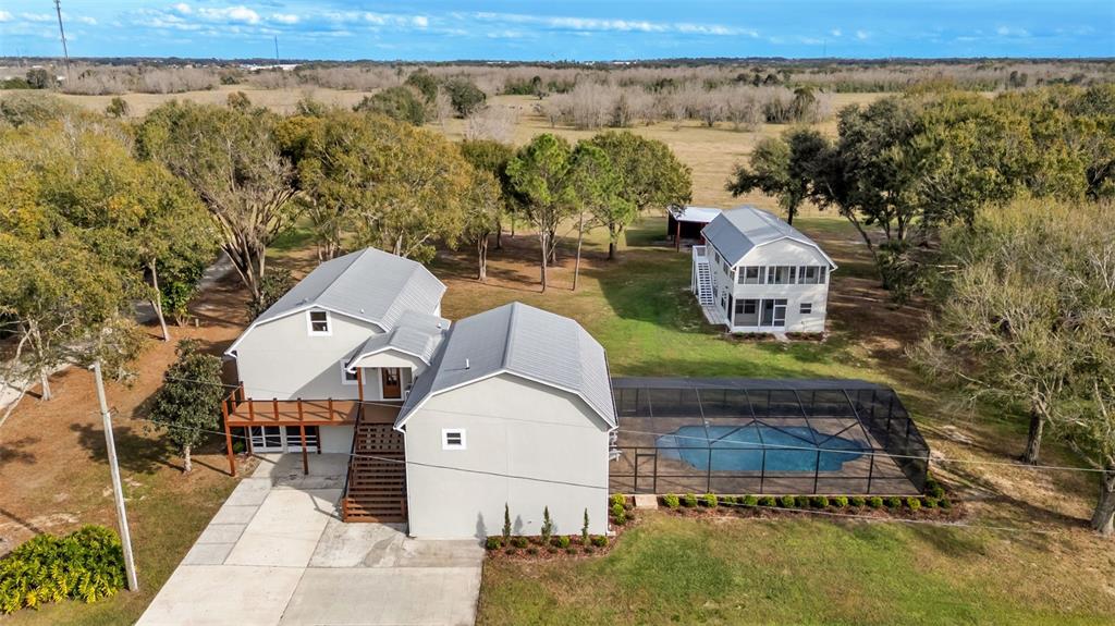 An aerial view shows two houses, a screened-in pool, and a large grassy yard — 13 BOGEY DRIVE, WINTER HAVEN, FL