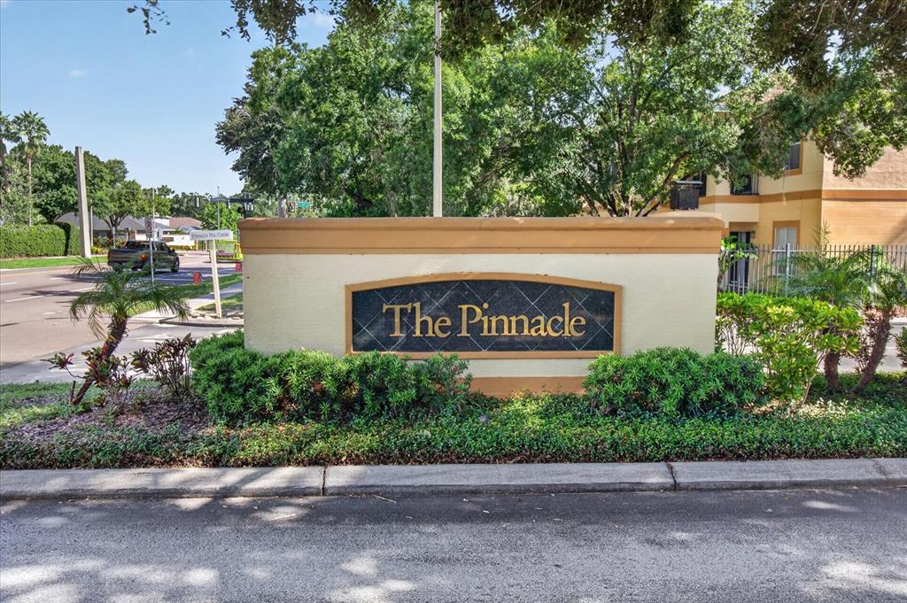 A beige monument sign with the text The Pinnacle stands in front of apartment buildings — 5608 PINNACLE HEIGHTS CIRCLE UNIT 305, TAMPA, FL