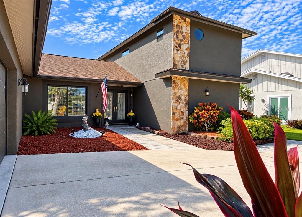 A covered patio features a swimming pool, a ceiling fan, and sliding glass doors — 2876 LAKE VALENCIA BOULEVARD E, PALM HARBOR, FL