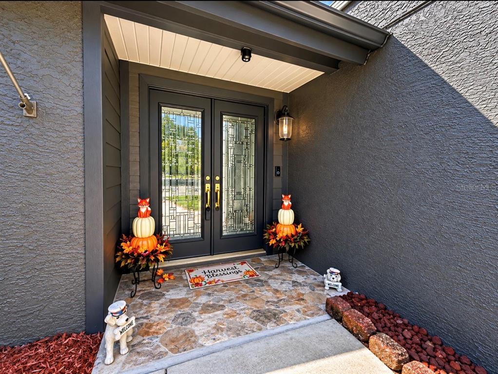 A screened-in pool enclosure with a concrete patio and a view of a pond — 2876 LAKE VALENCIA BOULEVARD E, PALM HARBOR, FL