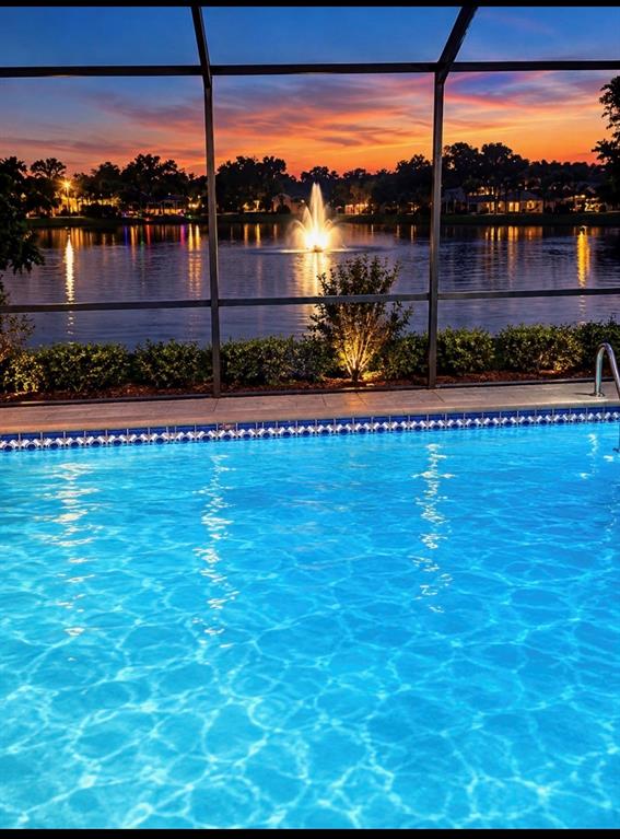 Aerial view of three suburban houses with swimming pools situated along a small lake — 2876 LAKE VALENCIA BOULEVARD E, PALM HARBOR, FL