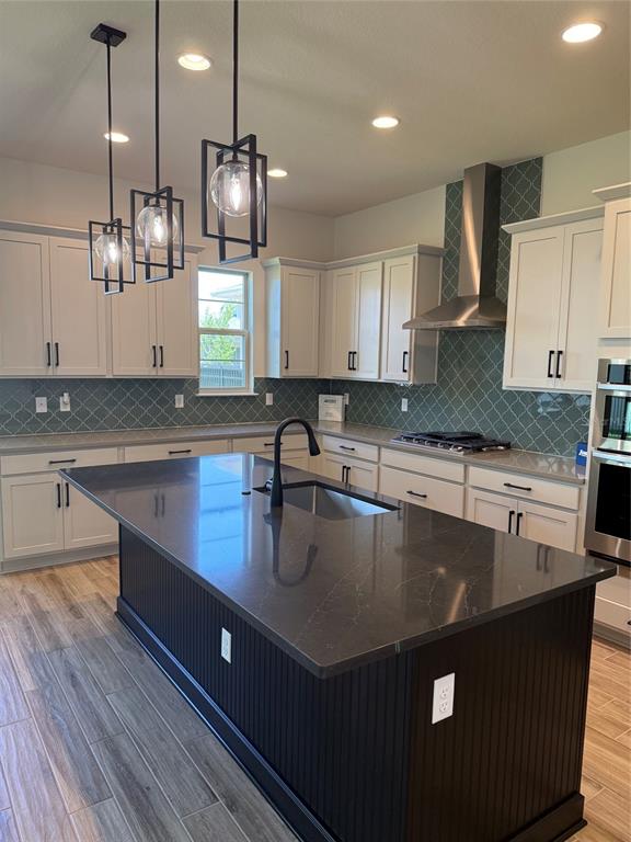 A kitchen features a dark island, white cabinetry, gray countertops, and a teal patterned backsplash — 5242 BUTTONSAGE DRIVE, ST CLOUD, FL