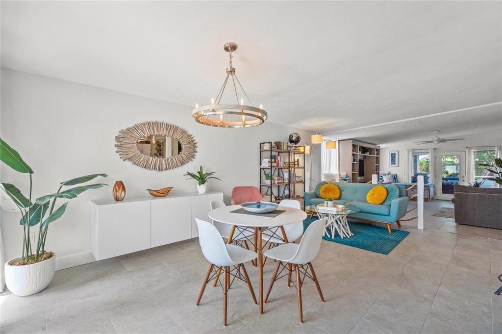 A dining area with a round table and white chairs sits adjacent to a living room — 4801 SARASOTA AVENUE, SARASOTA, FL