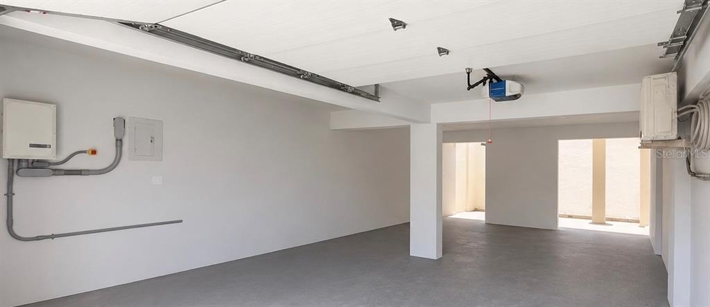 An empty garage features a concrete floor, white walls, and a ceiling-mounted garage door opener — 704 SANCHEZ UNIT 702, SAN JUAN, PR