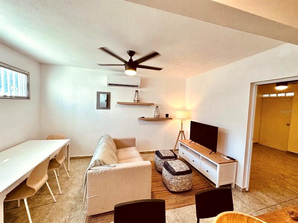 A living room with a sofa, dining table, television, and ceiling fan on tiled floors — 704 SANCHEZ UNIT 702, SAN JUAN, PR