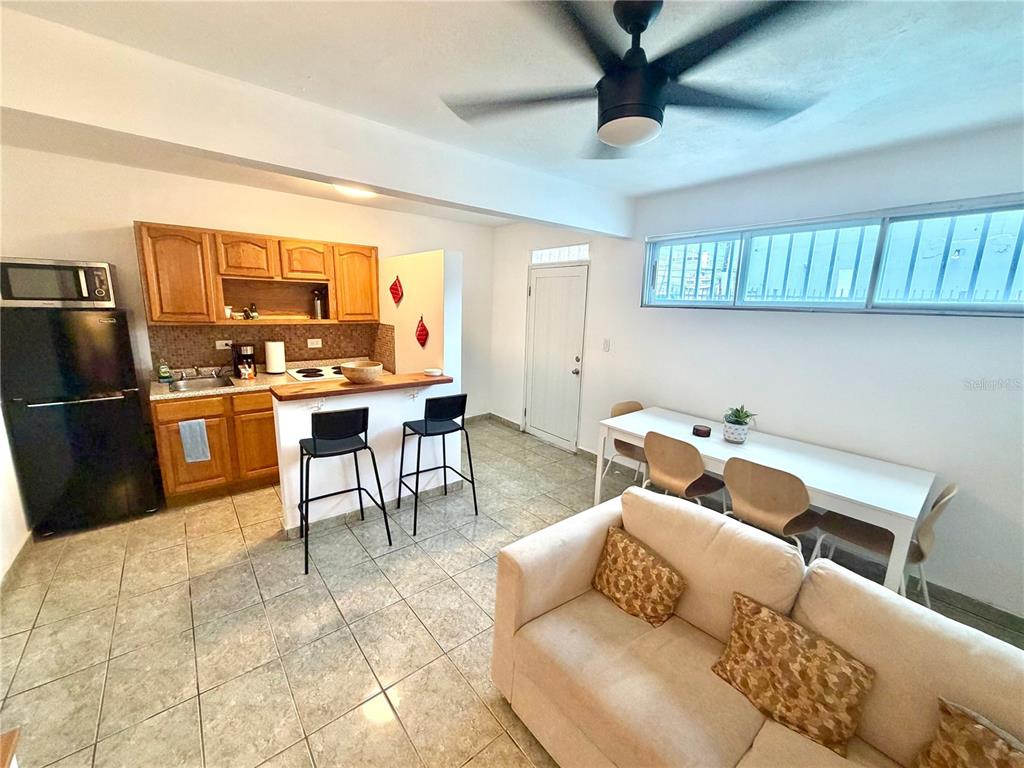 An open-concept kitchen, dining area, and living room with tile floors and a ceiling fan — 704 SANCHEZ UNIT 702, SAN JUAN, PR