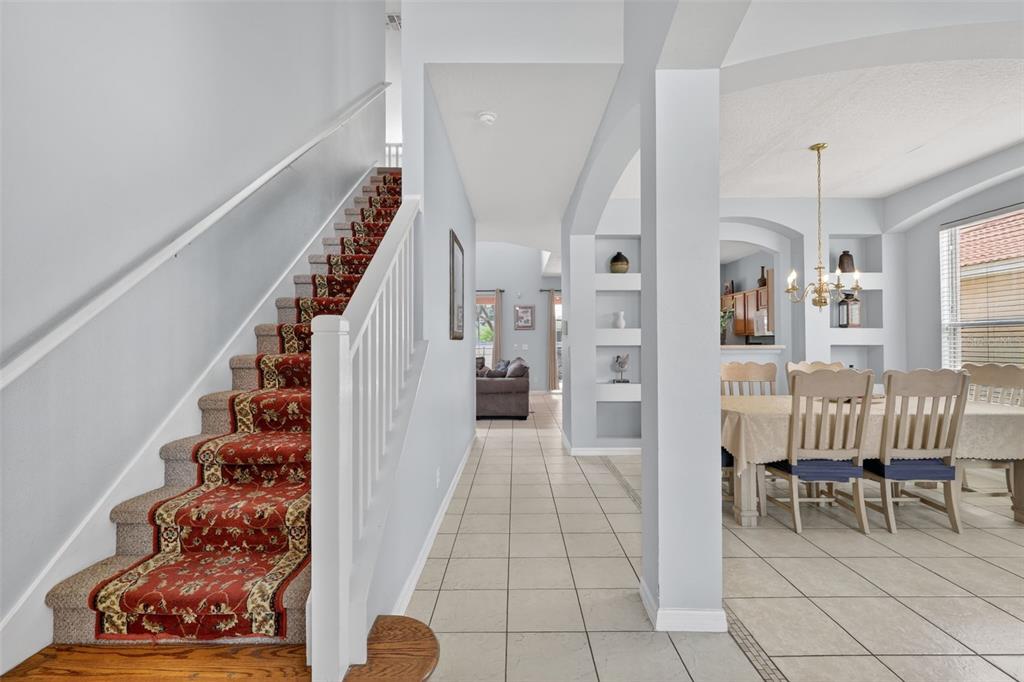 A foyer features a carpeted staircase with a red runner and a tiled dining area — 928 SOLANA CIRCLE, DAVENPORT, FL
