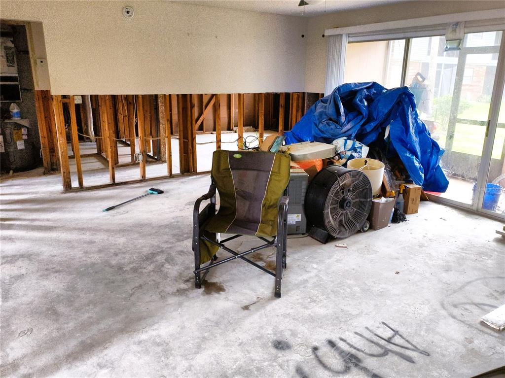 An interior room undergoing renovation with exposed wall studs, a concrete floor, and miscellaneous items — 200 COUNTRY CLUB DRIVE UNIT 805, LARGO, FL