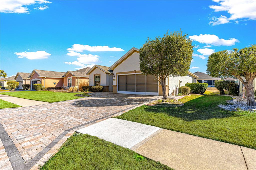 A single-story house with a paved driveway, a garage, and a manicured lawn — 9256 SW 66TH LOOP, OCALA, FL