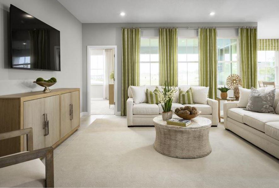 A living room features a light-colored sofa, a round coffee table, and green striped curtains — 8343 WENDY ROSE WAY, LEESBURG, FL