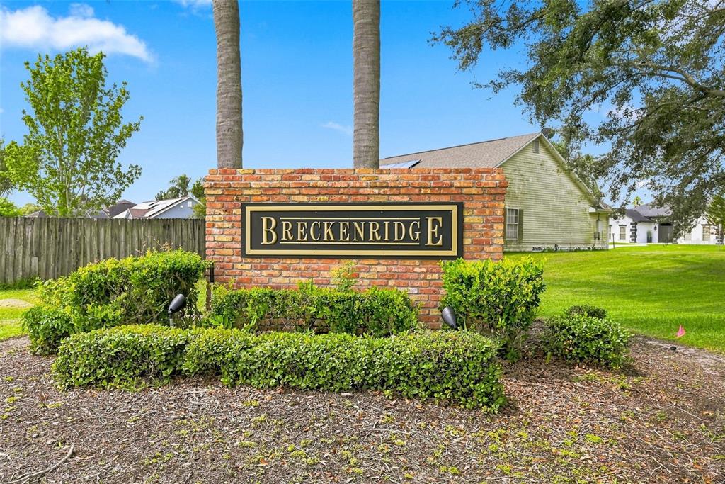 A brick monument sign for Breckenridge stands in front of a house and trees — 1791 LISA LANE, KISSIMMEE, FL