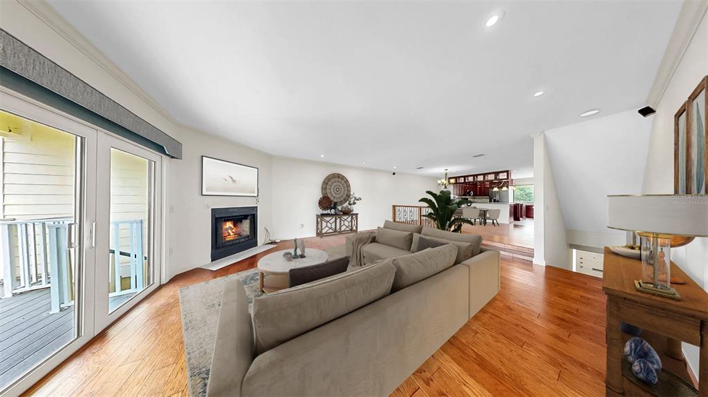 A living room with hardwood floors, a fireplace, and a sofa faces a dining area — 459 HAVEN POINT DRIVE, TREASURE ISLAND, FL